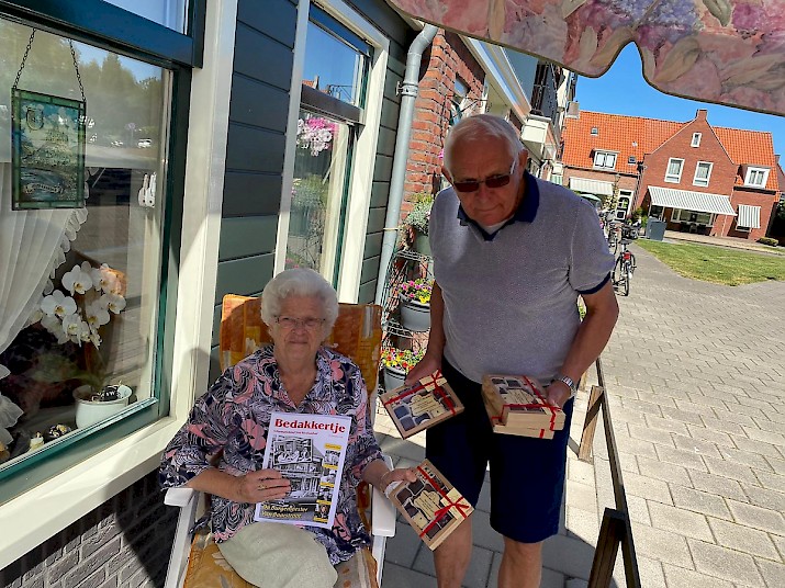 Mevrouw Snoek-Koning neemt het Bedakkertje en doosje chocolade in ontvangst.